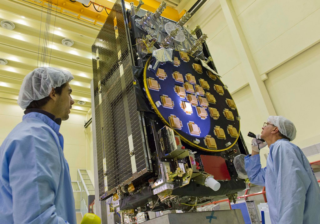 The main antenna of the second Galileo Full Operational Capability (FOC) satellite being inspected with a flashlight in advance of mass property testing during August 2013.