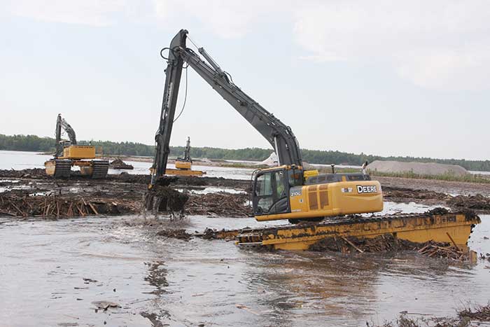 Amphibious excavators guided by GNSS in bay cleanup